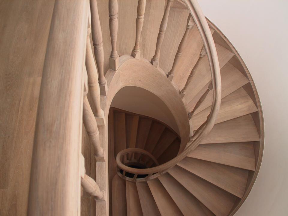 escalier 2/4 tournant classique avec limons cintrés (lamellé collé) en bois sur mesure. escalier à contre marches, fuseaux tournés, forme elliptique de l'escalier