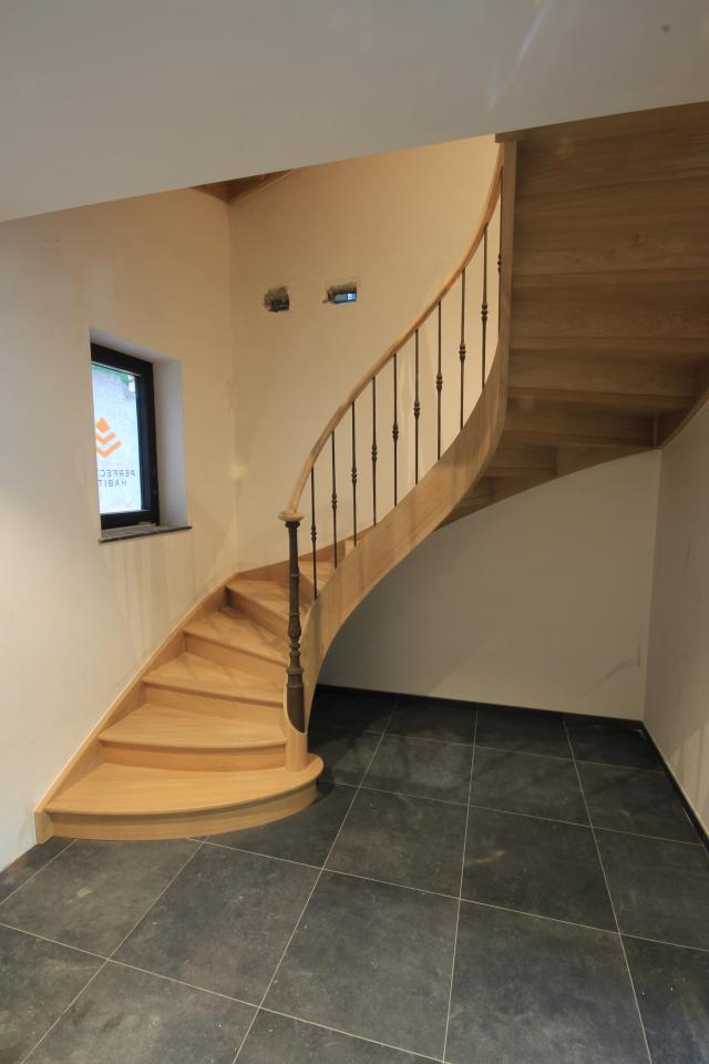 escalier balancé classique (2 quarts tournant) avec noyau évidé en bois sur mesure. escalier à contre-marche, colonnes et fuseaux en fonte