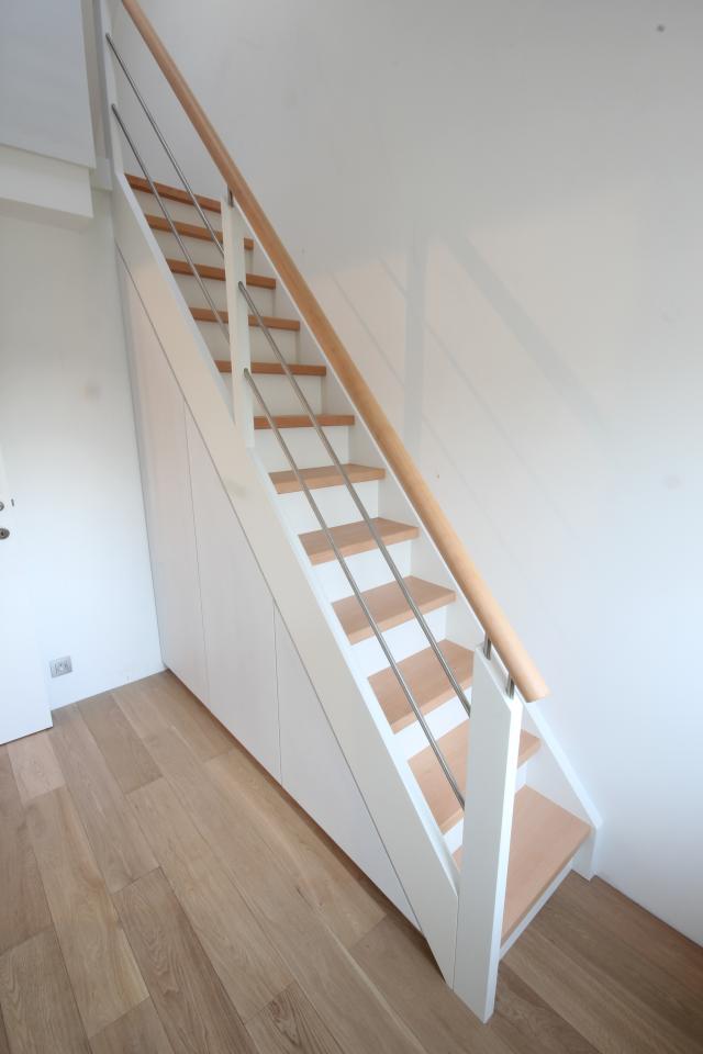 Escaliers droits à contre marche sur mesure avec espace de rangement en dessous de l'escalier. Main courante ronde en bois, Barres intermédiaires en inox.Bruxelles.