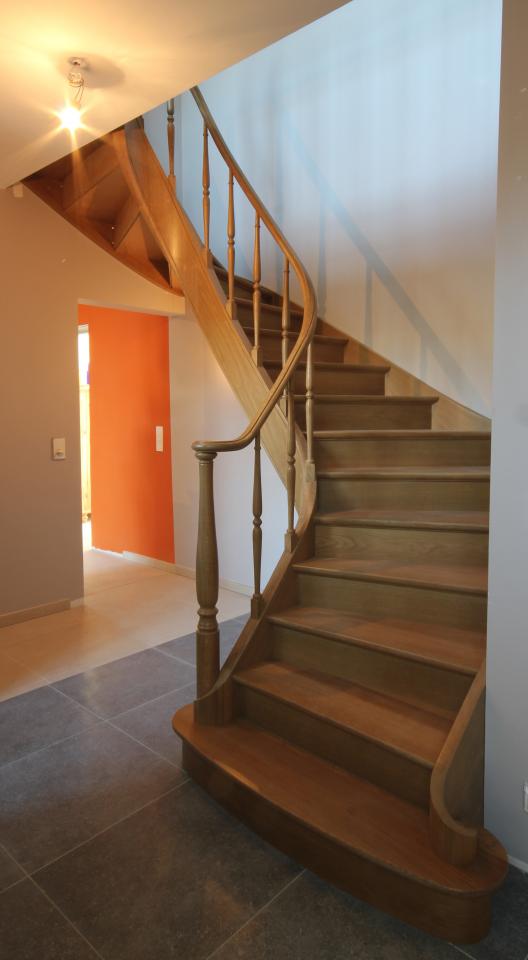 escalier balancé classique avec noyau évidé en bois sur mesure. marche de départ débordante, colonnes et fuseaux tournés en bois