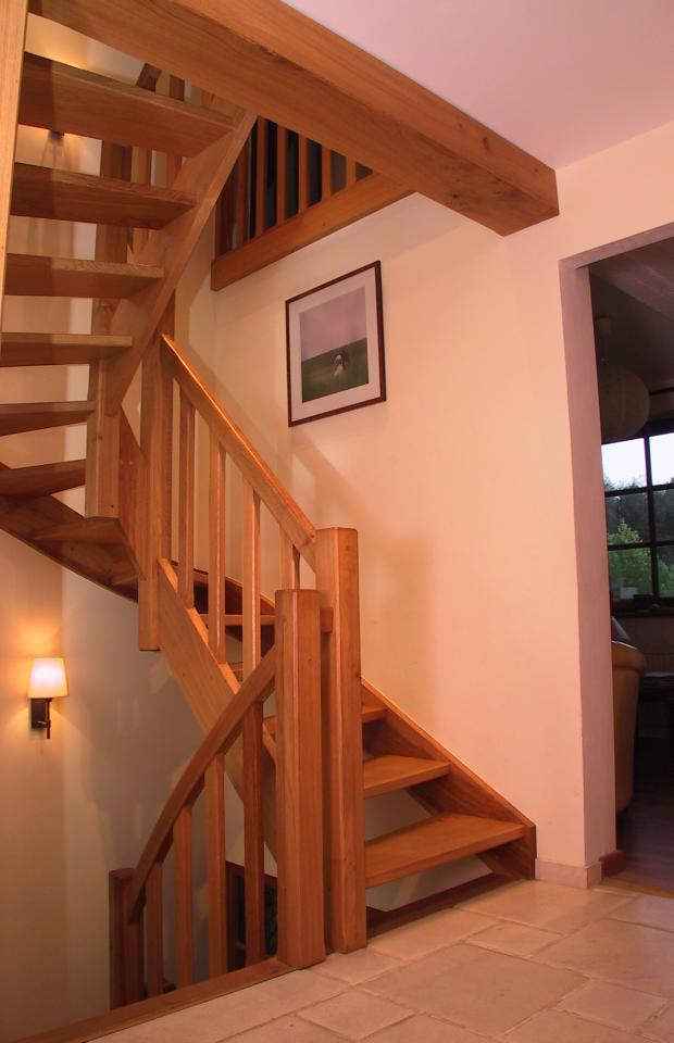 escalier balancé classique sur mesure en bois. Escalier 2 quarts tournants à claire voie. Colonnes droites et fuseaux plats.